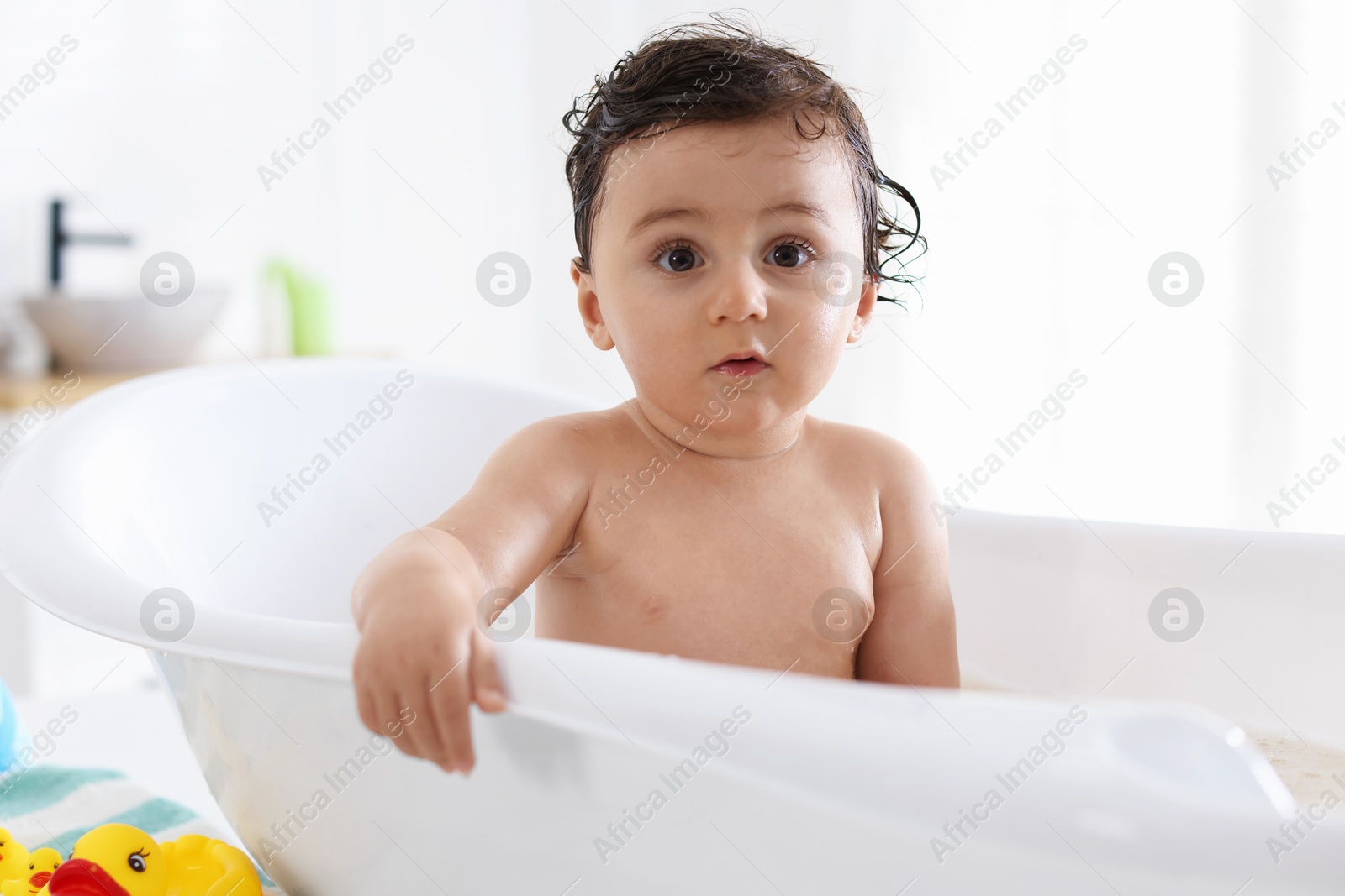Cute little baby bathing in tub at home Photo of Cute little baby bathing in tub at home