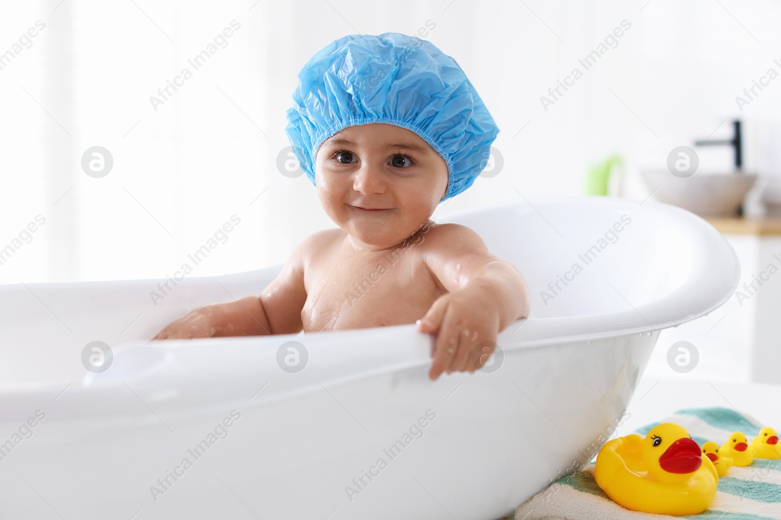 Cute little baby in cap bathing at home Photo of Cute little baby in cap bathing at home