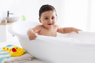 Photo of Cute little baby bathing in tub at home
