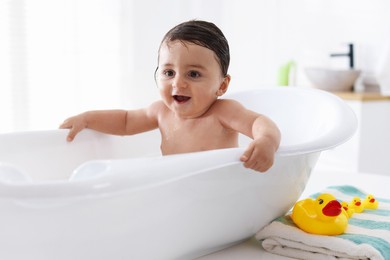 Photo of Cute little baby bathing in tub at home
