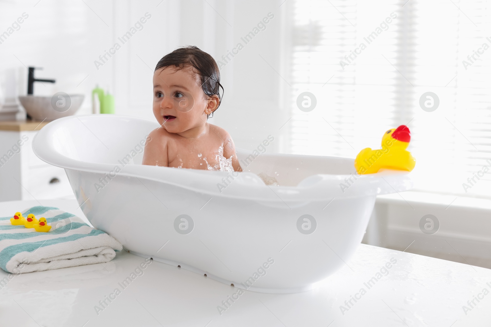 Cute little baby bathing in tub at home Photo of Cute little baby bathing in tub at home