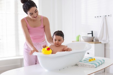 Photo of Mom giving bath to her little baby at home