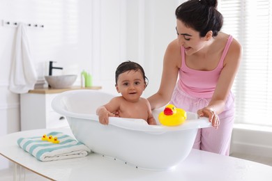 Photo of Mom giving bath to her little baby at home