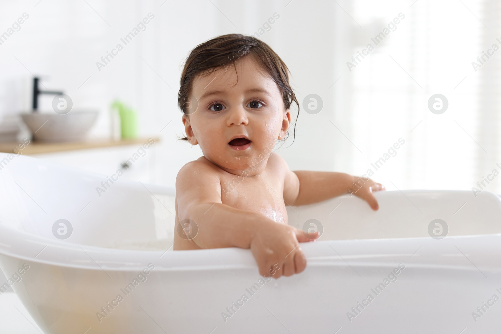 Cute little baby bathing in tub at home Photo of Cute little baby bathing in tub at home