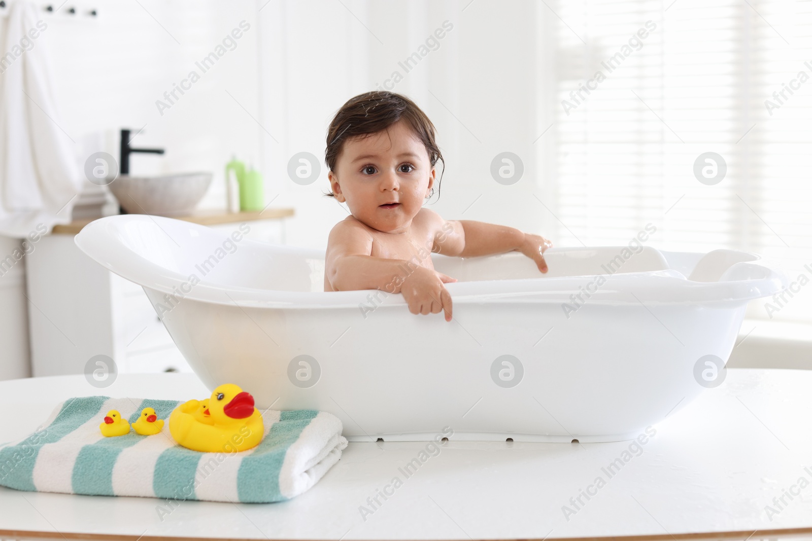 Cute little baby bathing in tub at home Photo of Cute little baby bathing in tub at home