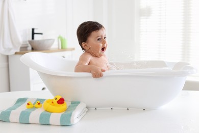 Photo of Cute little baby bathing in tub at home
