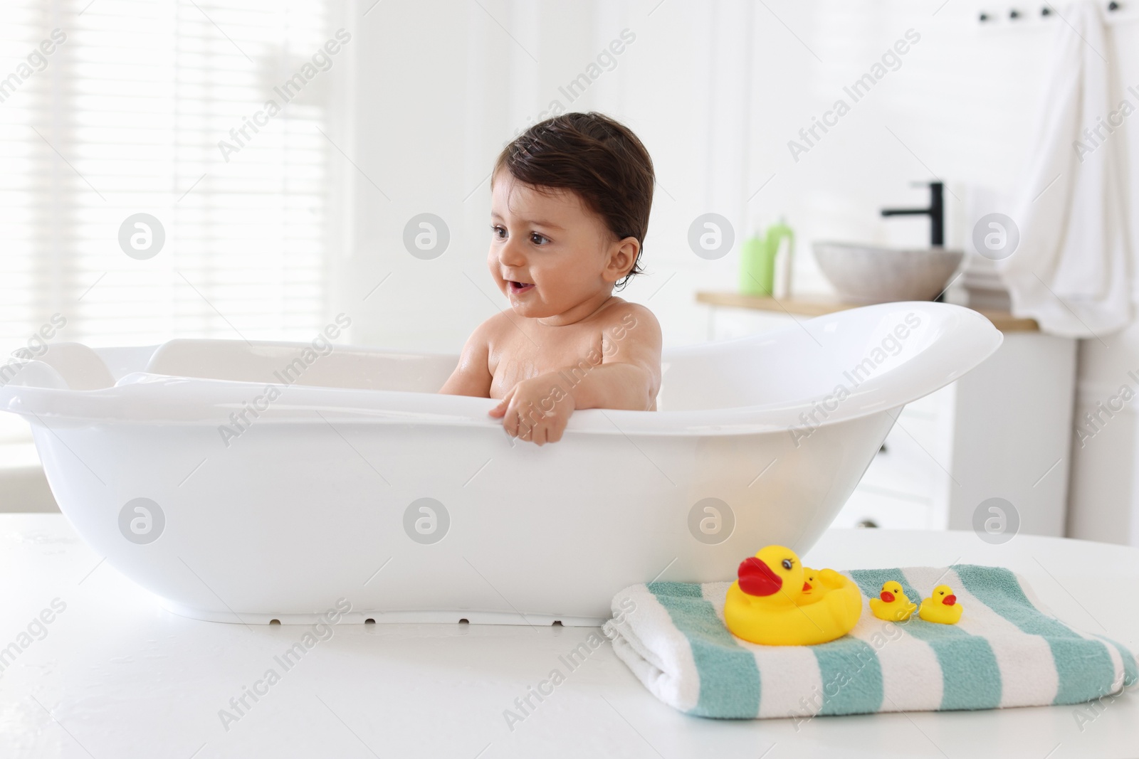 Cute little baby bathing in tub at home Photo of Cute little baby bathing in tub at home