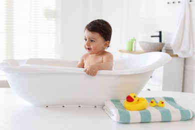 Photo of Cute little baby bathing in tub at home