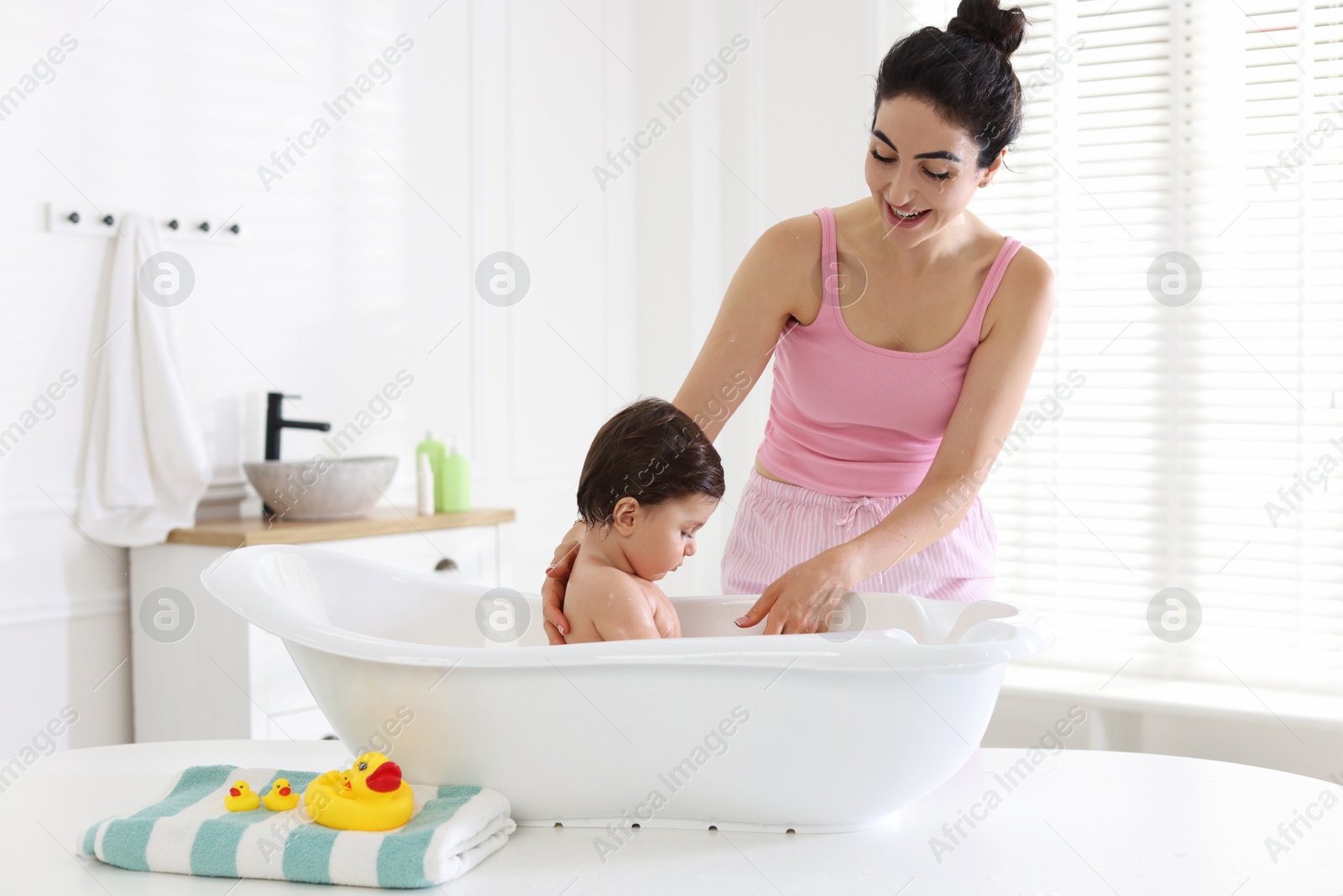 Mom giving bath to her little baby at home Photo of Mom giving bath to her little baby at home