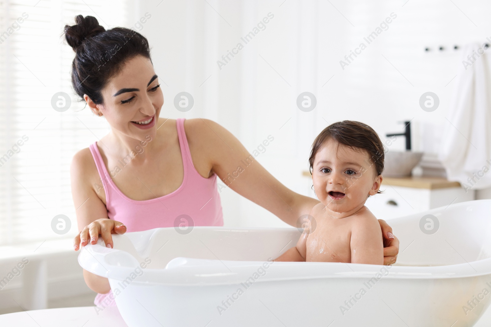 Mom giving bath to her little baby at home Photo of Mom giving bath to her little baby at home