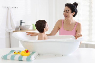 Photo of Mom giving bath to her little baby at home