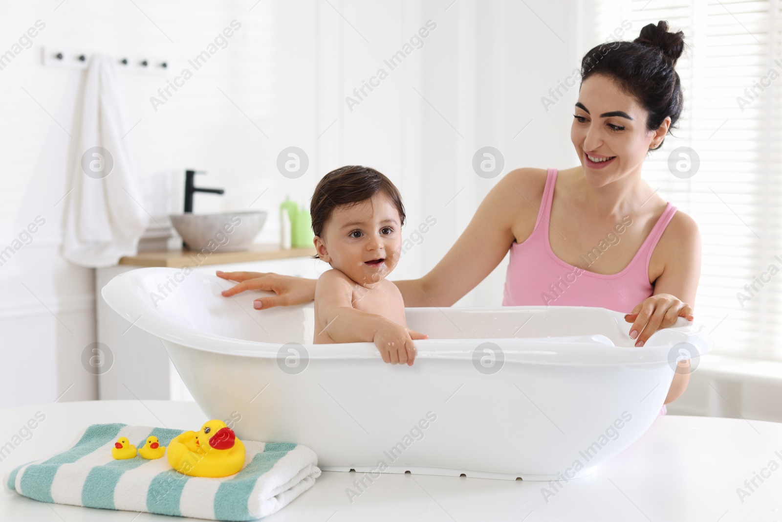 Mom giving bath to her little baby at home Photo of Mom giving bath to her little baby at home