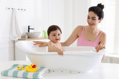 Photo of Mom giving bath to her little baby at home