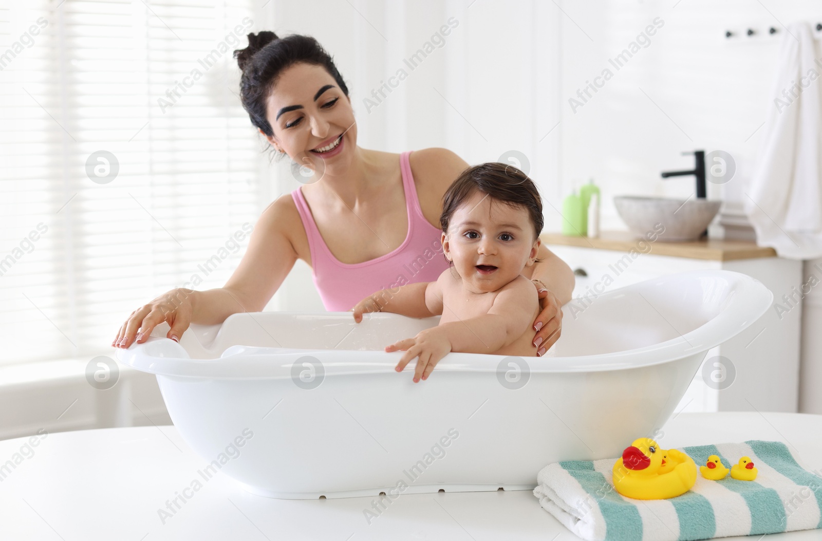 Mom giving bath to her little baby at home Photo of Mom giving bath to her little baby at home