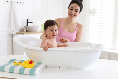 Photo of Mom giving bath to her little baby at home