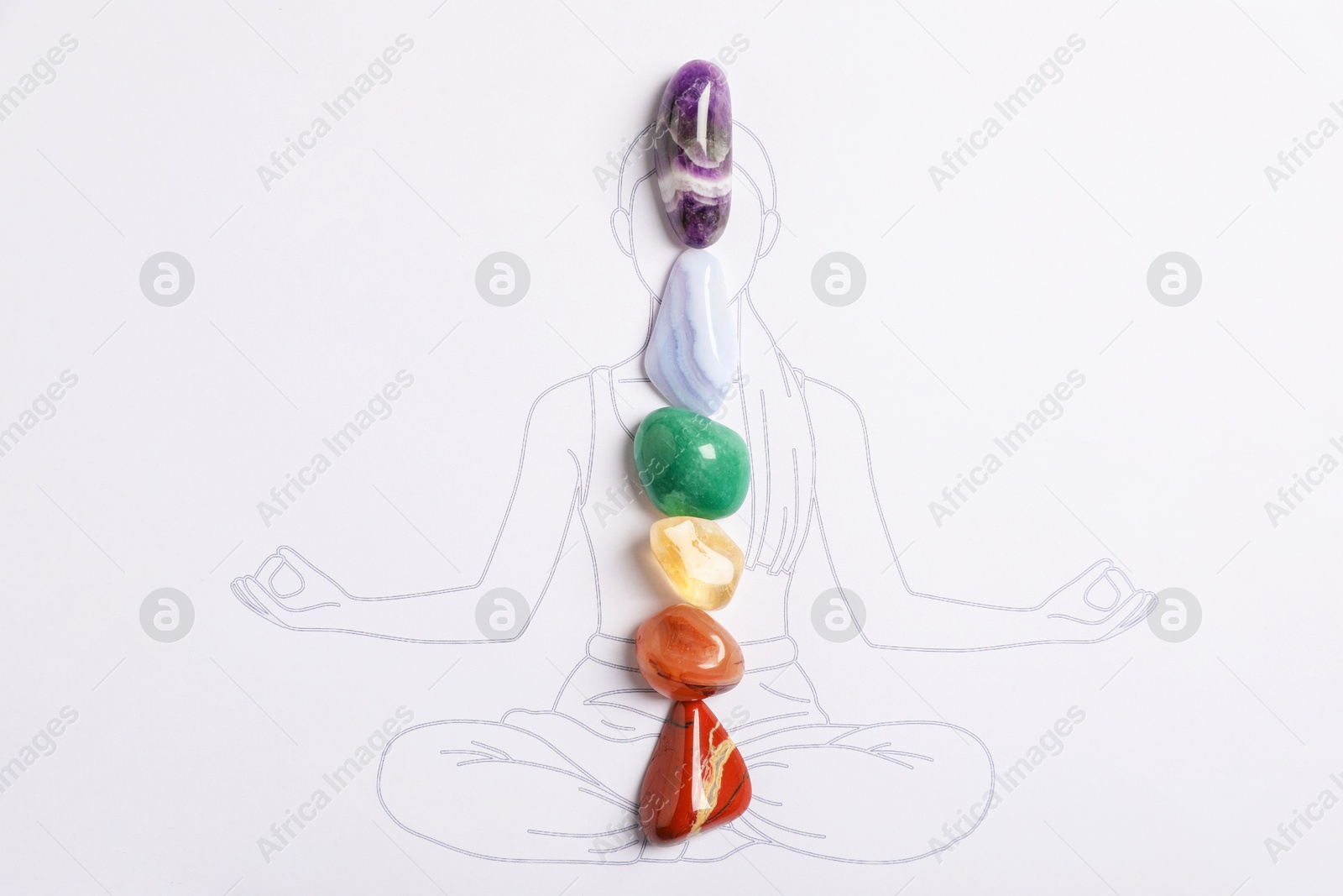 Human drawing with gemstones placed on chakras, top view Photo of Human drawing with gemstones placed on chakras, top view