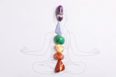 Photo of Human drawing with gemstones placed on chakras, top view