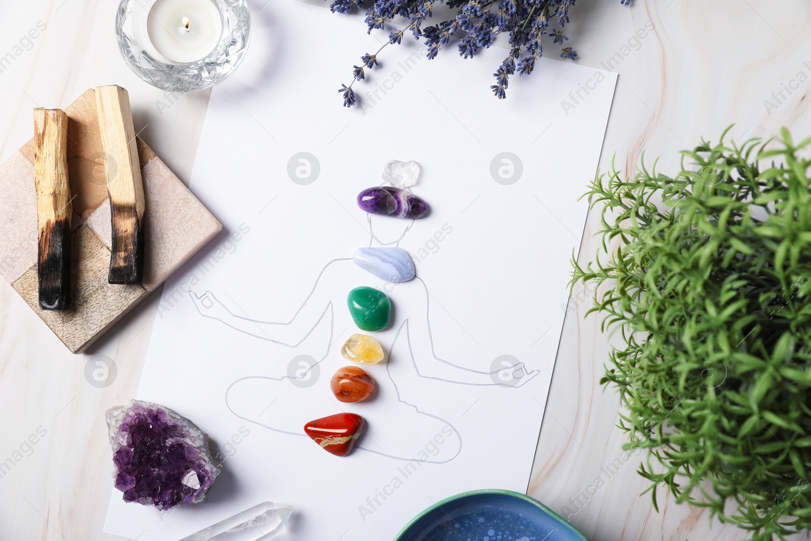 Human drawing with gemstones placed on chakras, plants and palo santo against white background, flat lay Photo of Human drawing with gemstones placed on chakras, plants and palo santo against white background, flat lay