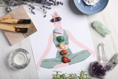 Photo of Human drawing with gemstones placed on chakras, plants and palo santo against white background, flat lay