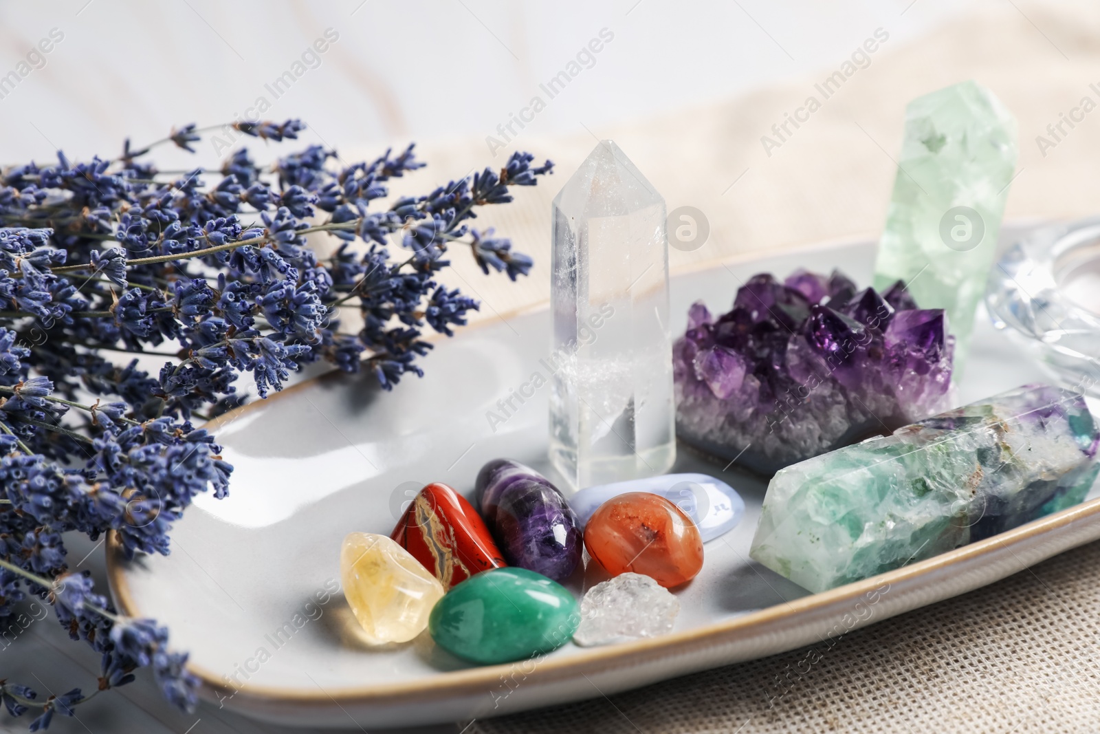 Different gemstones and lavender flowers on table, closeup Photo of Different gemstones and lavender flowers on table, closeup