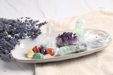 Photo of Different gemstones and lavender flowers on table, closeup