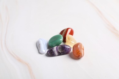 Photo of Natural chakra gemstones on white table, closeup