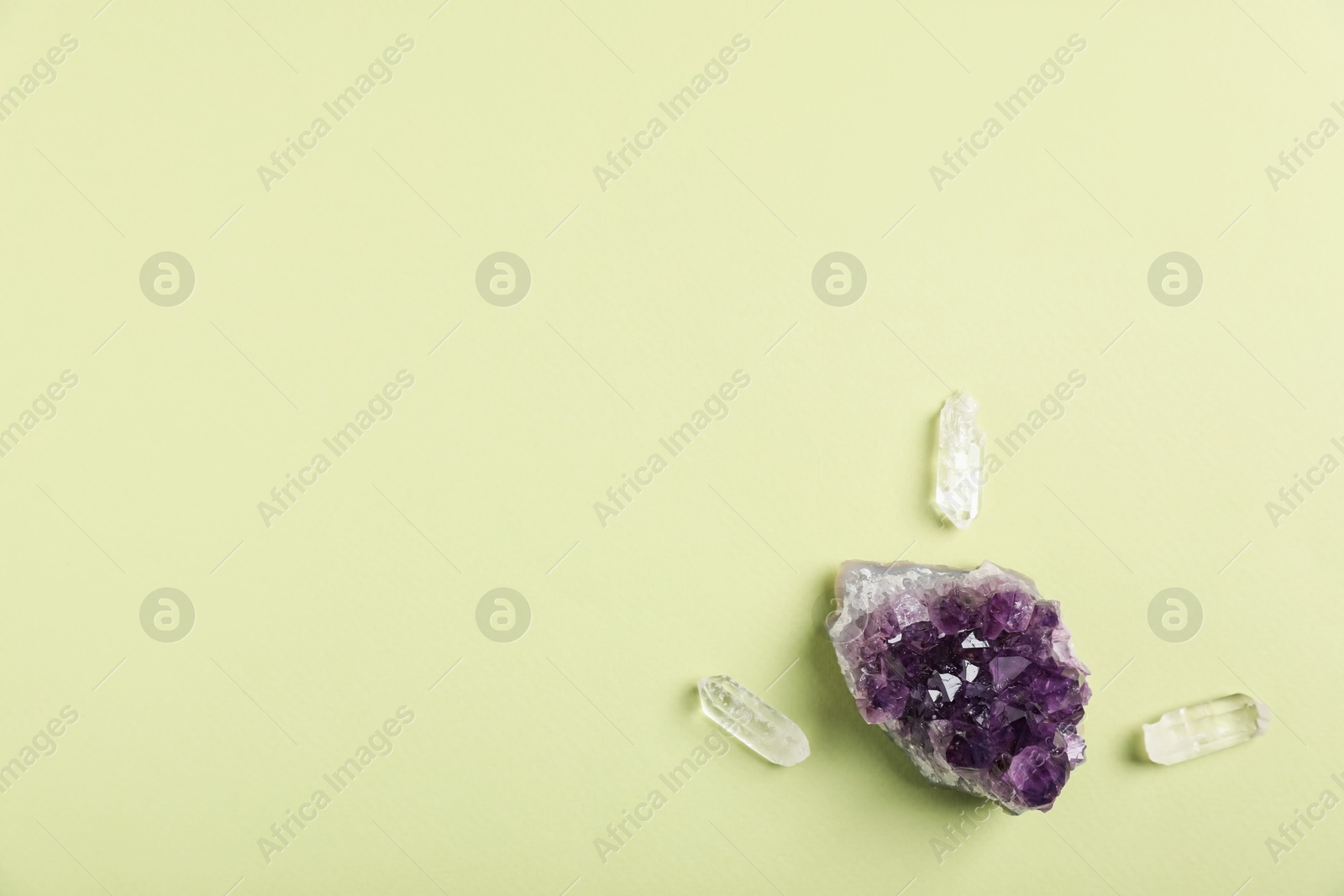 Different gemstones on light green background, flat lay. Space for text Photo of Different gemstones on light green background, flat lay. Space for text