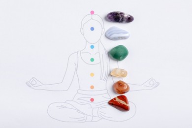 Photo of Human drawing with gemstones placed on chakras, top view