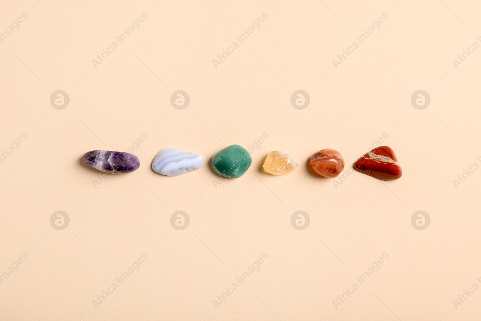 Chakra gemstones on beige background, flat lay Photo of Chakra gemstones on beige background, flat lay