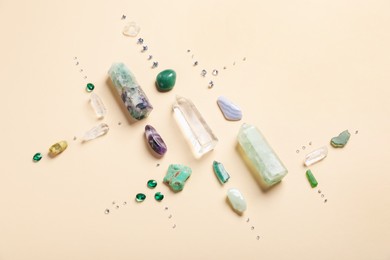 Photo of Different gemstones and crystals on beige background