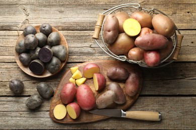 Photo of Different types of potatoes and knife on wooden table, flat lay