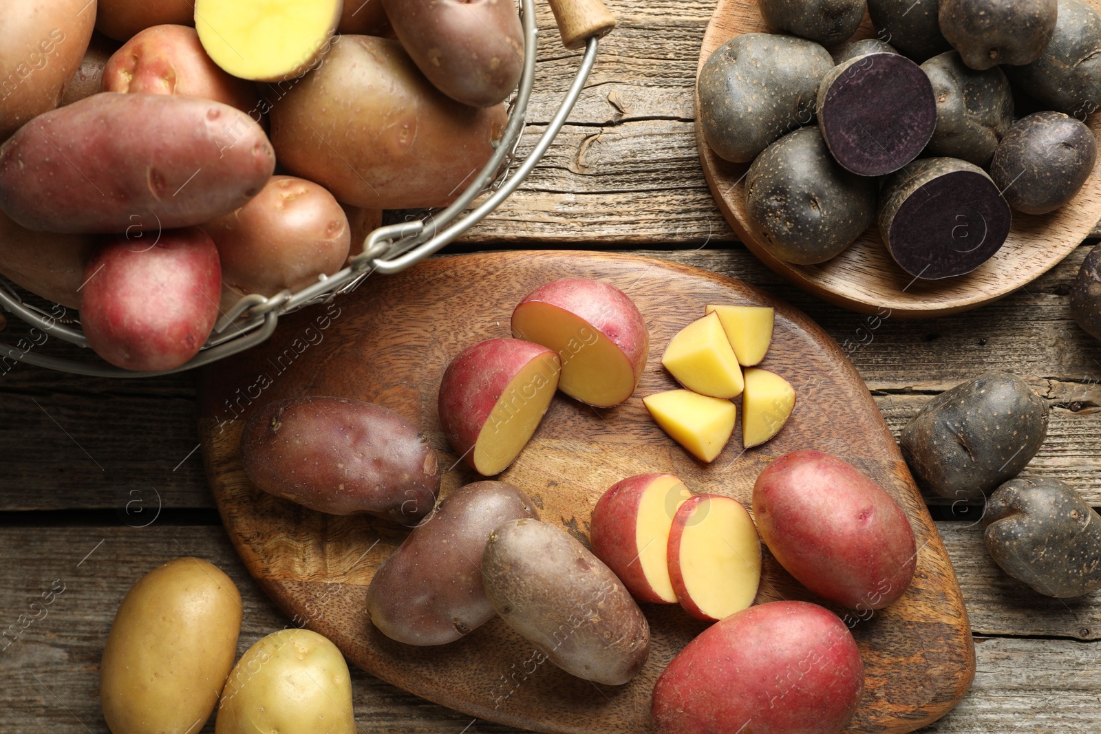 Photo of Different types of potatoes on wooden table, flat lay