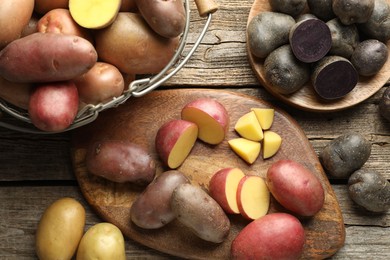 Photo of Different types of potatoes on wooden table, flat lay