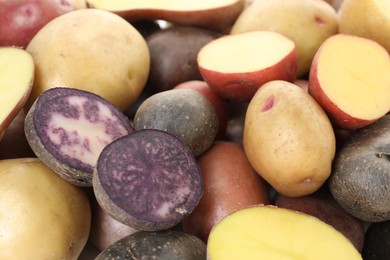 Photo of Different types of potatoes as background, closeup