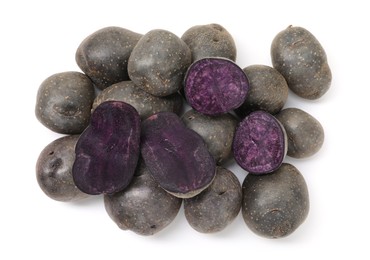 Photo of Whole and cut fresh purple potatoes isolated on white, top view