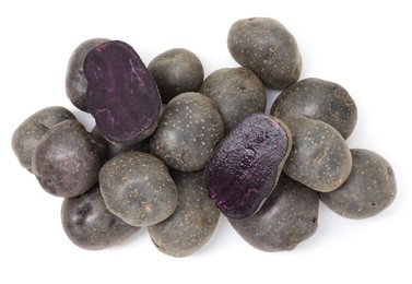 Photo of Whole and cut fresh purple potatoes isolated on white, top view