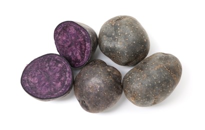 Photo of Whole and cut fresh purple potatoes isolated on white, top view