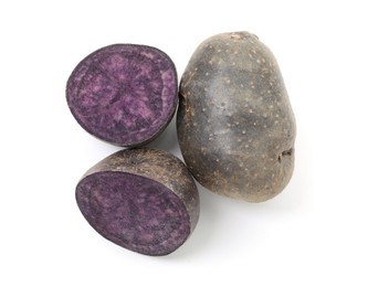 Photo of Whole and cut fresh purple potatoes isolated on white, top view