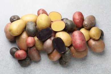 Photo of Different types of potatoes on grey table, flat lay