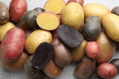 Photo of Different types of potatoes on grey table, flat lay