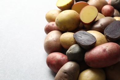 Photo of Different types of potatoes on grey table, closeup. Space for text