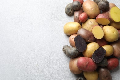 Photo of Different types of potatoes on grey table, flat lay. Space for text