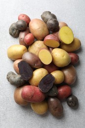 Photo of Different types of potatoes on grey table, flat lay