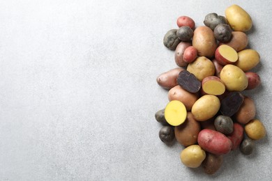 Photo of Different types of potatoes on grey table, flat lay. Space for text