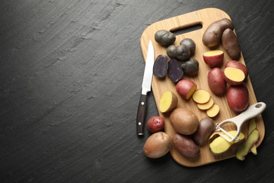 Photo of Different types of potatoes, peeler and knife on black table, flat lay. Space for text