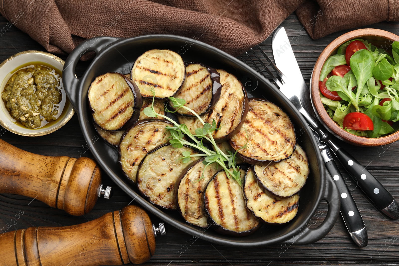 Photo of Grilled slices of eggplant with microgreens served on wooden table, flat lay