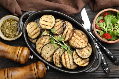 Photo of Grilled slices of eggplant with microgreens served on wooden table, flat lay