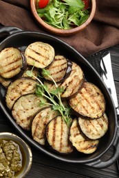 Photo of Grilled slices of eggplant with microgreens served on wooden table, flat lay