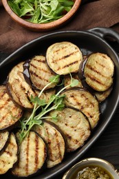 Photo of Grilled slices of eggplant with microgreens served on wooden table, flat lay