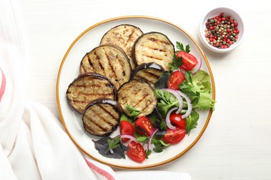Photo of Grilled slices of eggplant with salad and peppercorns on white wooden table, top view